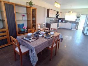 mesa de comedor con sillas y cocina en Petros House Artemis - Near the Airport, en Artemida