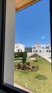 une fenêtre avec vue sur un parc et des bâtiments dans l'établissement Achakar, à Tanger