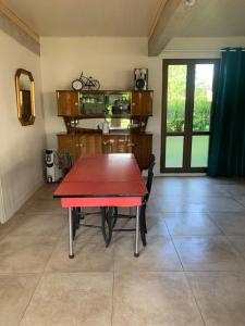 uma sala de jantar com uma mesa vermelha num quarto em Gîte ferme Saint Gauthier 