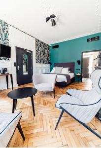 een slaapkamer met een bed en 2 stoelen en een tafel bij La villa 10 HÔTEL SPA in Étretat