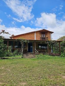una vieja casa de ladrillo en un campo de hierba en Chalés Vila Carrancas - Unidade Serra en Carrancas