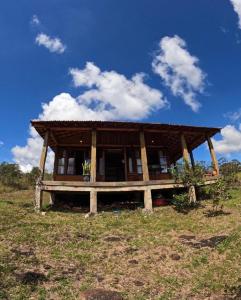 una pequeña casa con techo en un campo en Chalés Vila Carrancas - Unidade Serra, en Carrancas