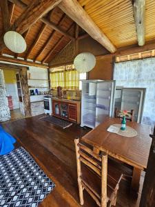 a large kitchen with a wooden table and refrigerator at Chalés Vila Carrancas - Unidade Serra in Carrancas