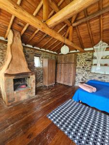 a living room with a fireplace in a stone building at Chalés Vila Carrancas - Unidade Serra in Carrancas