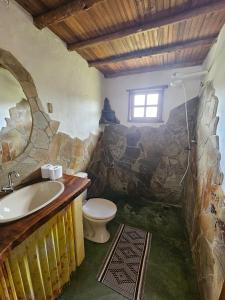 a stone bathroom with a sink and a toilet at Chalés Vila Carrancas - Unidade Serra in Carrancas