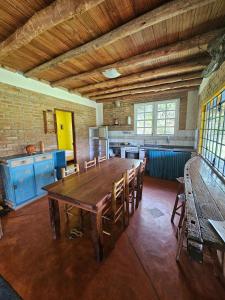 a large kitchen with a wooden table and chairs at Chalés Vila Carrancas - Unidade Serra in Carrancas
