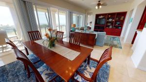 a dining room with a wooden table and chairs at MAJESTIC OCEAN Majestic Mauna Kea Condo with Golf and Ocean Views in Hapuna Beach