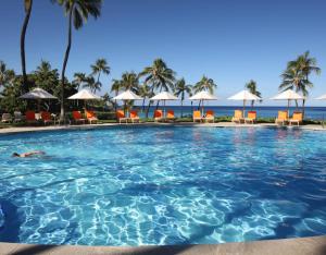 a swimming pool at a resort with the ocean in the background at MAJESTIC OCEAN Majestic Mauna Kea Condo with Golf and Ocean Views in Hapuna Beach