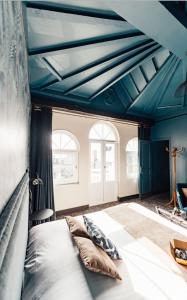 a bedroom with blue ceilings and a bed with pillows at La villa 10 HÔTEL SPA in Étretat