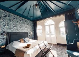 a bedroom with a bed with a blue ceiling at La villa 10 HÔTEL SPA in Étretat