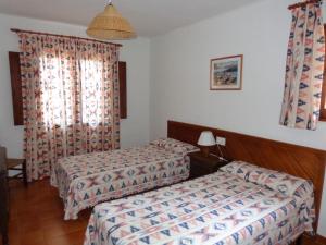 a hotel room with two beds and a window at Apartamentos Los Pinares Benet in Santa Eularia des Riu +19 photos