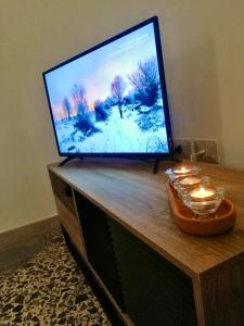 a flat screen tv sitting on top of a wooden table at La Casa verde in Galatone