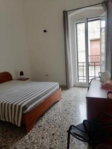 a bedroom with a bed and a desk and a window at La Casa verde in Galatone