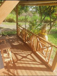 a wooden deck with a bench and a plant at Ti Oasis SEAVIEW à 200m de la Plage in Corps de Garde