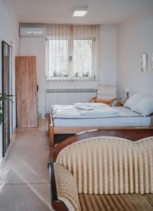 a bedroom with two beds and two windows at MASAL Studio Apartman in Bihać