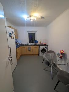 uma cozinha com um frigorífico, uma mesa e um micro-ondas em Ali's Flat em Londres