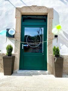 una porta verde con due piante in vaso davanti di B&B Staziona e Dormi a Camigliatello Silano