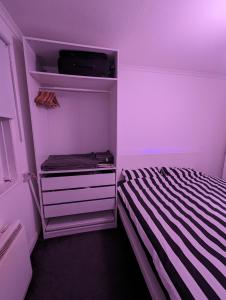 um pequeno quarto com uma cama e um tecto roxo em Ali's Flat em Londres