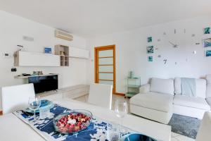 una sala de estar blanca con mesa y sillas en Residenza Quadrifoglio, en Cesena