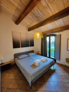 1 dormitorio con cama y techo de madera en Rustico del Bozzo, en Castelleone di Suasa