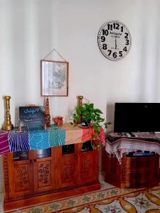 una habitación con un reloj en la pared y una mesa en Cactus & Mandala en Birżebbuġa