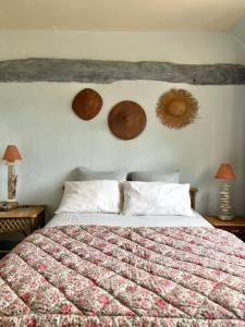 1 dormitorio con 1 cama con edredón y 2 lámparas en Chambres d'Hôtes Manoir Du Chêne, en Nonant