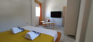 Chariot Apartments Santorini في كماري: غرفة نوم عليها سرير وفوط