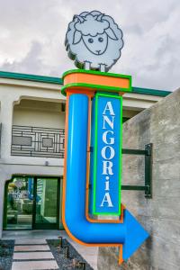 un panneau avec un mouton au-dessus d'un bâtiment dans l'établissement Angoria Hotel, à San Angelo
