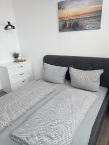 a bed with two pillows and a nightstand at FeWo Krabbe in Wilhelmshaven