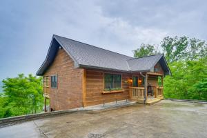 eine Holzhütte mit einer Veranda und einer Terrasse in der Unterkunft Gatlinburg Cabin in the Clouds with Hot Tub and Views! in Gatlinburg