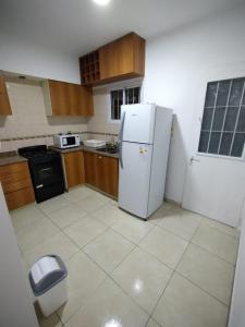 a kitchen with a white refrigerator and a trash can at Hermoso Duplex en San Miguel in General Sarmiento +12 photos