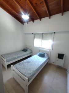 a bedroom with two beds and a tv in it at Hermoso Duplex en San Miguel in General Sarmiento