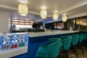 un bar avec des chaises vertes dans un restaurant dans l'établissement Angoria Hotel, à San Angelo