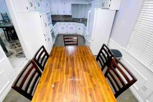 uma cozinha com uma mesa de madeira e 2 cadeiras em Vacation Home with Private Pool em Dallas