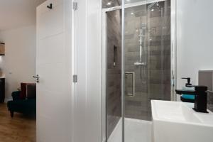 una ducha con una puerta de cristal junto a un lavabo en Coach House by Coppergate Grimsby, en Great Coates