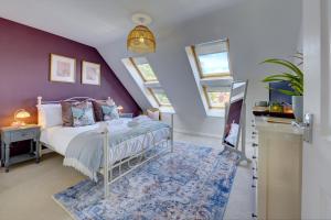 Market House by Spa Town Property - Spacious & Stylish Townhouse with Free Parking Near to Stratford-upon-Avon, Warwick & Solihull في هينلي-إن-أردن: غرفة نوم بسرير وجدار ارجواني