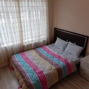 a bedroom with a bed with a colorful blanket at 73 / 3 in Elazığ