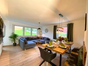 a living room with a table and a blue couch at Moderne EG-Wohnung im Günztal in Krumbach