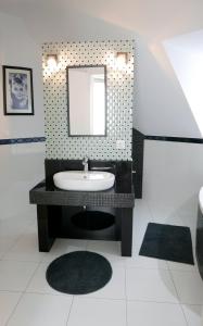 y baño con lavabo y espejo. en Downtown Luxury apartman, en Szentendre