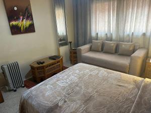 Appartement Wassim - Gueliz في مراكش: غرفه فندقيه بسرير واريكه