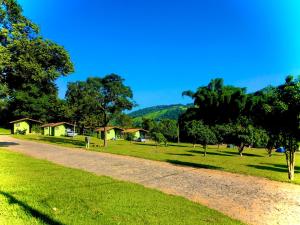 een onverharde weg in een park met bomen en huizen bij Pousada e Camping Recanto da Praia in Capitólio