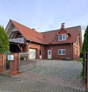 a brick house with a gate on a driveway at Ferienwohnung Seeblick in Neu Schloen