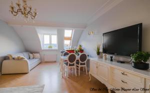 uma sala de estar com uma televisão e uma mesa com cadeiras em Sea & City 50 m Monte Casinno 100 m Beach Apartments Lux Sopot em Sopot