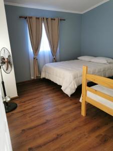 a bedroom with a bed and a wooden floor at Cabañas Nonito in Pozo Almonte