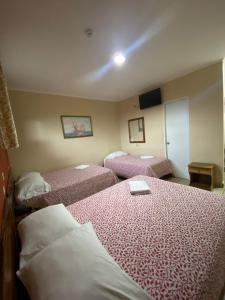 een hotelkamer met 2 bedden met roze lakens bij Hotel Residencial Panamericano in David