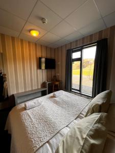 1 dormitorio con cama y ventana en Hótel Skógafoss by EJ Hotels en Skogar