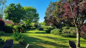 a garden with trees and flowers on a lawn at Kyriad Angoulême Nord Champniers- Hôtel & Résidence in Champniers