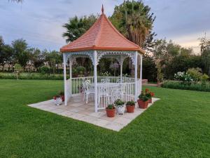 a gazebo in a yard with potted plants at Villa Sardinia Guest House in Midrand