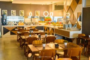 a restaurant with wooden tables and chairs and a counter at DM HOTEL in Propriá