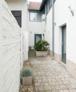 una casa con una pared blanca y una pasarela en Downtown Luxury apartman, en Szentendre